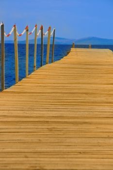 wooden peer on blue sea with blue sky 