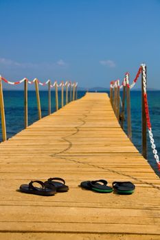 slippers on wooden peer consept of going vacation