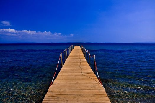 wooden peer on blue sea with blue sky 