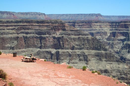 GRAND CANYON WEST RIM, Arizona - June 8 2008: A couple sitting on the precipice admiring the view at the West Rim of the Grand canyon.