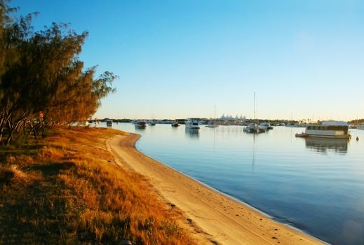 Houseboats and yachts moored in the Broadwater Gold Coast Australia on a golden morning.