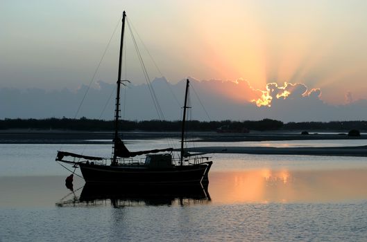 Ancient old ketch moored peacefully at sunrise.