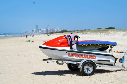 Lifeguard jet ski sits on the beach with Surfers Paradise in the background on the Gold Coast Australia.