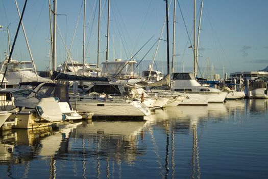 Boats and yachts lined up at the marina in the early morning golden light.