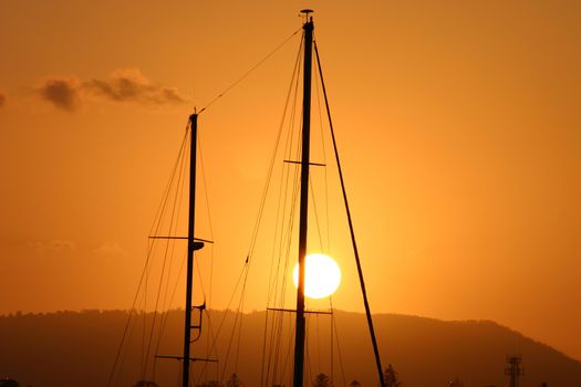 Two masts framed against the setting sun.