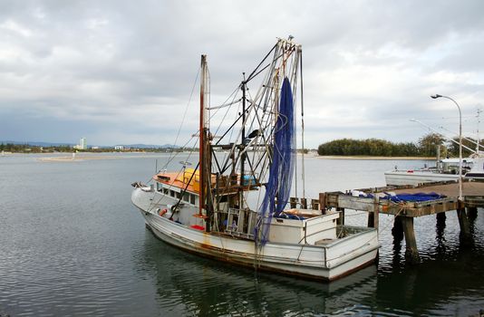 Prawn trawler sits at dock on an overcast day.