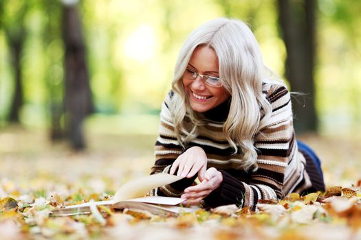 woman read the book in autumn park