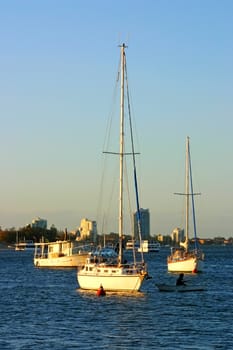 Yachts and boats at anchor in the setting sun at the end of the day.