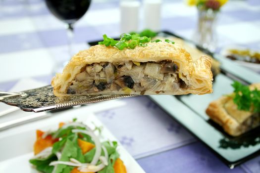 Mushroom and leek strudel on a spatula with pumpkin and rocket salad.