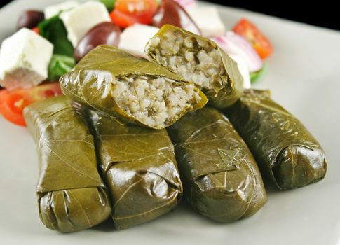 Greek dolmades wrapped with vine leaves and rice with salad.