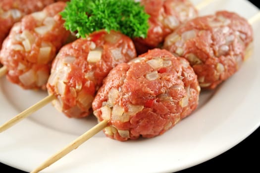 Raw beef kofta on skewers ready to cook.