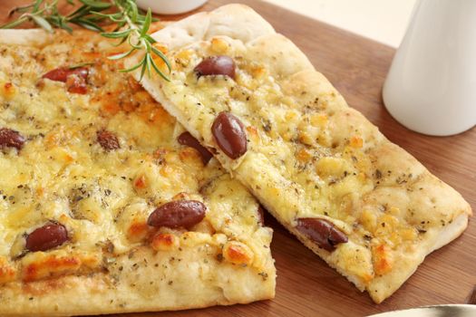 Rectangular gourmet pizza with cheese and olives ready to serve.