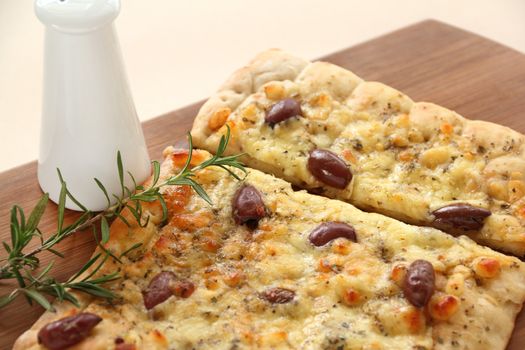 Rectangular gourmet pizza with cheese and olives ready to serve.