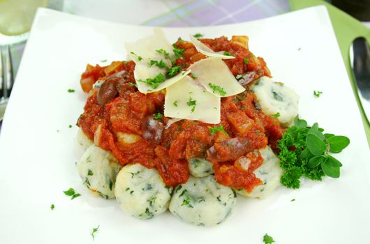 Delicious spinach gnocchi with a tomato and olive sauce.