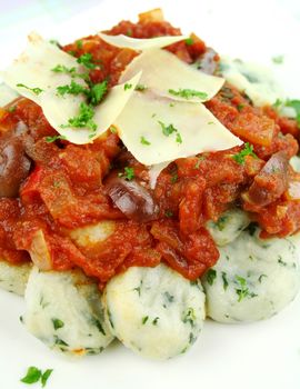 Delicious spinach gnocchi with a tomato and olive sauce.