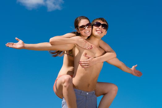 Young couple hugging on a background of blue sky, hold together honeymoon