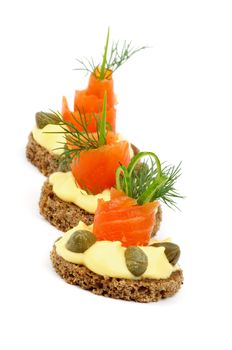 Three Delicious Snacks with Smoked Salmon, Greens, Cheese Cream and Capers In a Row isolated on white background