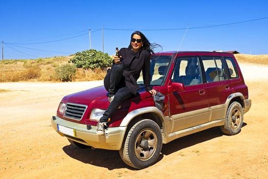 Woman drinking beer in the desert