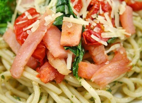 Spaghetti with bacon, pesto, sundried tomato and baby spinach topped with parmesan cheese.