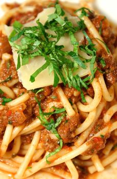 Bolognese sauce combined with spaghetti with cheese and garnish.