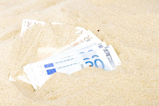 Euro banknotes in the sand