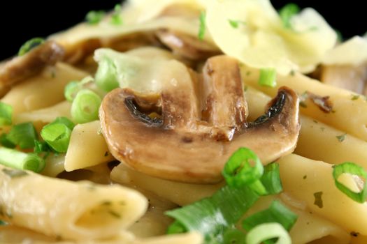 Creamy mushroom penne pasta with shredded cheese.