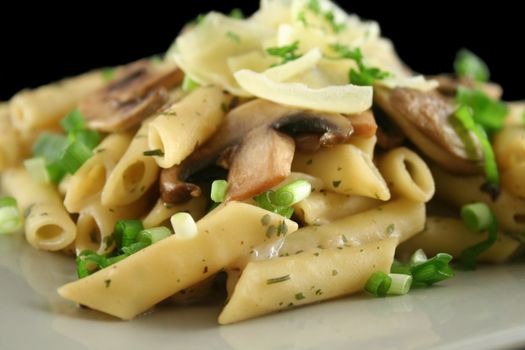 Creamy mushroom penne pasta with shredded cheese.