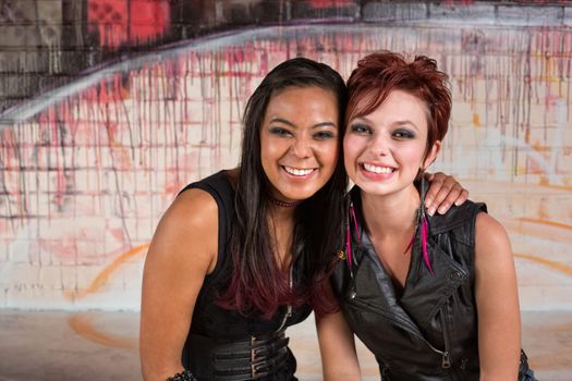 Pair of smiling young friends sitting together