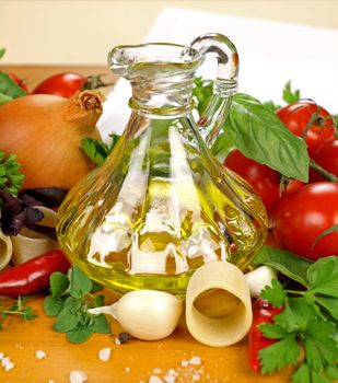 Ingredients for making pasta including olive oil, roma tomatoes, pasta, basil and parsley.