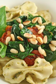 Pasta with pesto and spinach, cherry tomatoes and pine nuts.