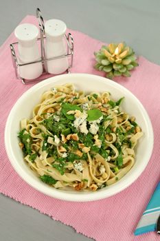 Fettucini with spinach blue cheese and walnuts with a mint garnish.