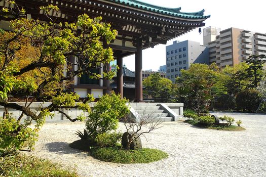 Contrast of Buddhist Temple in foreground and skyscrapers in background. Fukuoka Japan.