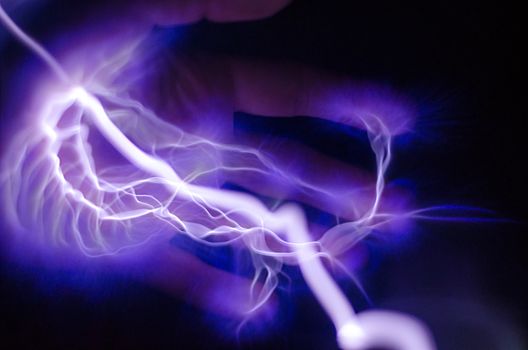 A hand with purple and blue lightning coming out of it
