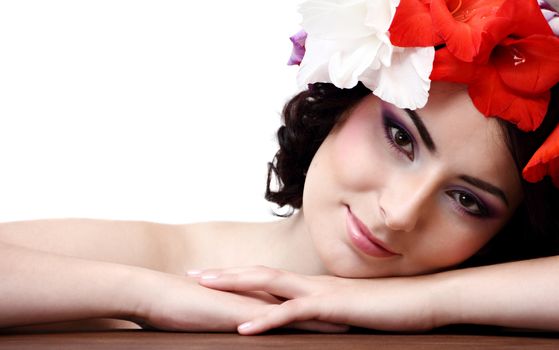 Beautiful young woman with flowers in their hair looks at the camera