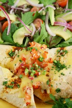 Beef and red kidney bean enchiladas with cheese and salad.