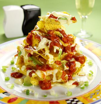 Delicious stack of nachos with guacamole and melted cheese.