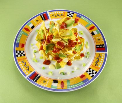 Delicious stack of nachos with guacamole and melted cheese.