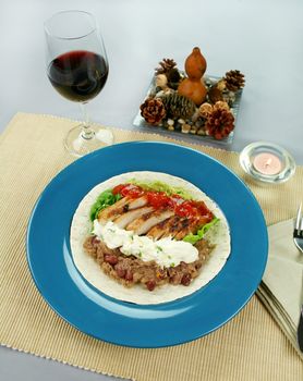 Open chicken tortilla with refried beans, guacamole and sour cream with chives.