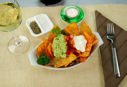 Delicious vegetarian nachos with guacamole, tomato salsa and sour cream.