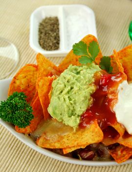 Delicious vegetarian nachos with guacamole, tomato salsa and sour cream.