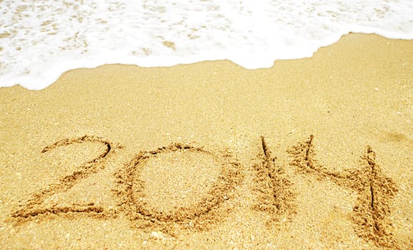 A new year 2014 written in sand on a beach