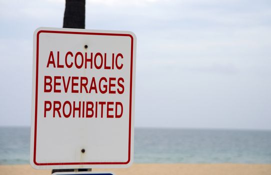 alcoholic beverages prohibited on beach sign with ocean in background