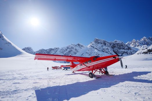 a red plane landing on a glacier in alaska