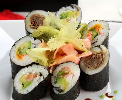 Sushi comprising prawn and avocado rolls, beef rolls and salmon and avocado rolls.