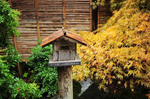 japanese house-style donation box in japanese garden