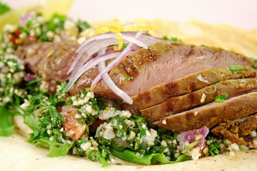 Sliced Middle Eastern lamb fillet with hommus and tabouleh.