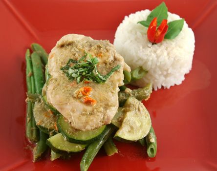Delicious Thai green poached chicken with green beans and zucchini and rice.