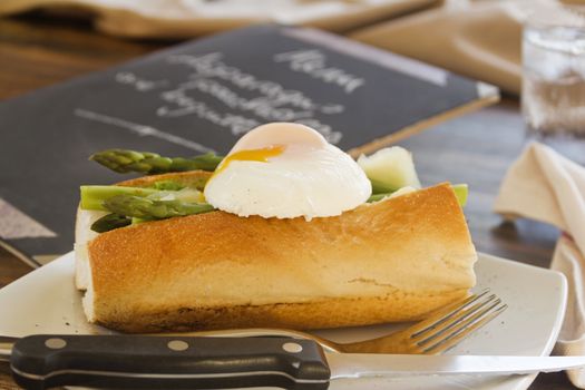 Delicious asparagus and mashed peas topped with a poached egg on a crispy baguette.