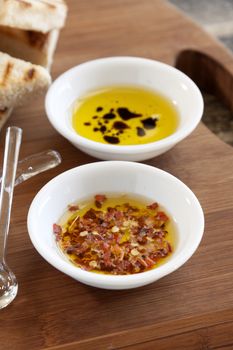 Condiments consisting of dried chilli flakes and balsamic vinegar in olive oil.