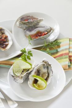 Platter of oysters including oysters kilpatrick, with sweet chilli and with lime and soy sauce.